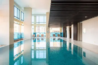 a large swimming pool in a building with glass windows at M Estate Private Residence 3BR, Heart of Bangkok in Bangkok