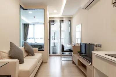 a living room with a couch and a television at Bts thonglo 700m free wifi & gym in Ban Hua Khao Sisiat
