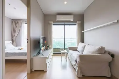 a living room with a couch and a bed at Lumpini Suite Phetchaburi Siam Square Nana in Ban Non Phatthana