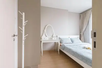 a bedroom with a bed and a dressing table and a mirror at Lumpini Suite Phetchaburi Siam Square Nana in Ban Non Phatthana