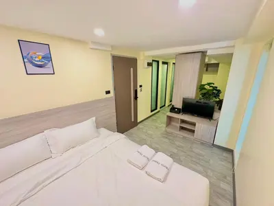 a bedroom with a white bed and a television at Nona Hotel, Bangkok in Makkasan