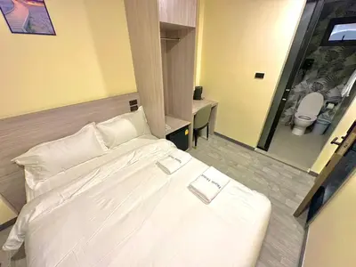 a large white bed in a room with a bathroom at Nona Hotel, Bangkok in Makkasan