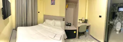a small bedroom with a bed and a desk at Nona Hotel, Bangkok in Makkasan