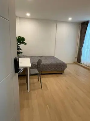 a room with a bed and a desk and a table at 33 Avenue in Bangkok