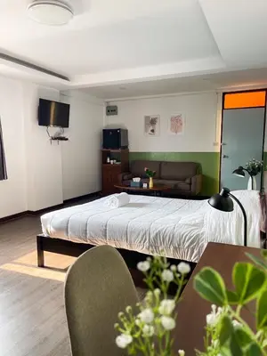 a hotel room with a bed and a couch at Jaruchok Apartment in Bangkok
