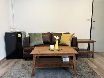 a living room with a couch and a coffee table at Jaruchok Apartment in Bangkok
