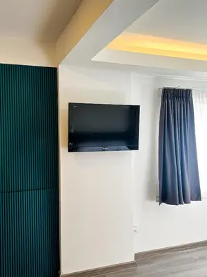 a room with a flat screen tv on a wall at Jaruchok Apartment in Bangkok