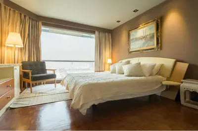 a bedroom with a bed and a chair and a window at Sukhumvit Boutique Suite : Soi 13/ 10min. from BTS Nana station in Bangkok
