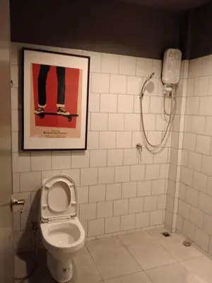 a bathroom with a toilet and a picture on the wall at STAY-DIUM House Huamark in Ban Bang Toei (1)