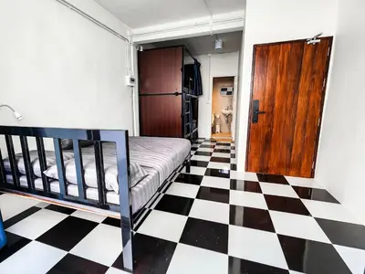 a bedroom with a black and white checkered floor at Noir Cafe And Hostel Chinatown Bangkok in Chinatown