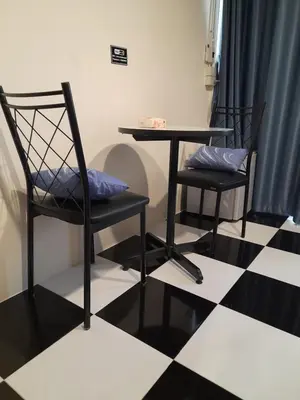 a table and two chairs sitting on a checkered floor at Noir Cafe And Hostel Chinatown Bangkok in Chinatown