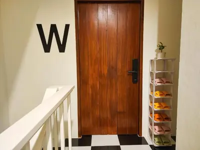 a wooden door in a hallway next to a staircase at Noir Cafe And Hostel Chinatown Bangkok in Chinatown