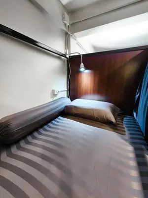 a large bed in a room with avertisementatronatronstrationstrationstrationstrationstration at Noir Cafe And Hostel Chinatown Bangkok in Chinatown