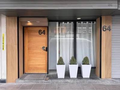 a front door of a building with two potted plants at Vélin Khaosan - 3rd Floor apartment with 2Bedrooms in Bangkok