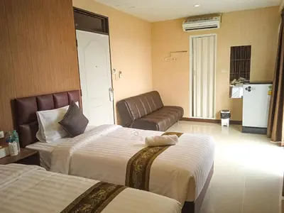 a hotel room with two beds and a couch at KS HOUSE in Bangkok