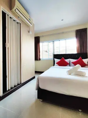 a bedroom with two beds with red pillows at KS HOUSE in Bangkok