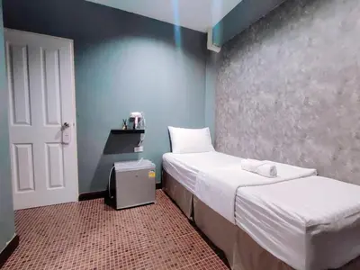 a bedroom with two beds and a blue wall at KS HOUSE in Bangkok