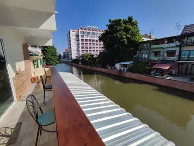 a view of a river from a balcony with chairs at KS HOUSE in Bangkok