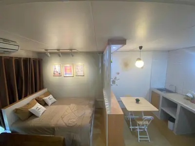 a small room with a bed and a table and a sink at PTJ Style Condotel คอนโดเมืองทอง in Ban Bang Phang