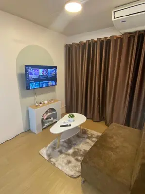 a living room with a couch and a table and a tv at PTJ Style Condotel คอนโดเมืองทอง in Ban Bang Phang