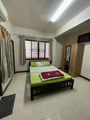 a bedroom with a bed in a room with a window at Pimravee Apartment (Yaek 8) in Ban Zong Katiam