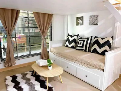 a bedroom with a bed with a window and a table at Relax in town,Grand Palace in Bangkok