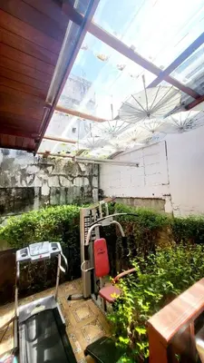 a greenhouse with a red chair and plants at Aran Cottage Ngamwongwan The Pool Villa in japanese Garden in Nonthaburi