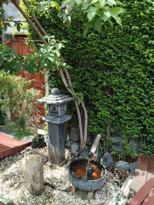 a bird bath and a fountain in a garden at Aran Cottage Ngamwongwan The Pool Villa in japanese Garden in Nonthaburi