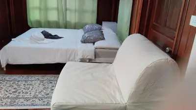a living room with two beds and a couch at Aran Cottage Ngamwongwan The Pool Villa in japanese Garden in Nonthaburi