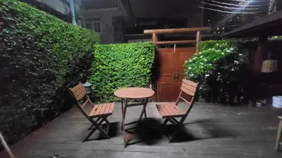 a table and two chairs sitting next to a table at Aran Cottage Ngamwongwan The Pool Villa in japanese Garden in Nonthaburi