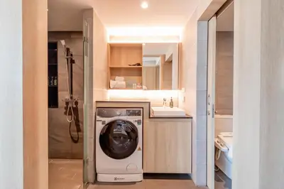 a bathroom with a washing machine and a sink at LiveZen Bangkok Sukhumvit in Khlong Toei