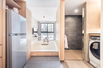 a kitchen with a refrigerator and a washer and dryer at LiveZen Bangkok Sukhumvit in Khlong Toei
