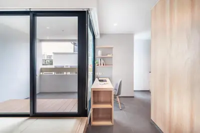 a room with a desk and a sliding glass door at LiveZen Bangkok Sukhumvit in Khlong Toei