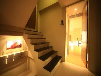 a staircase in a living room with a fireplace at Silom One in Bangkok