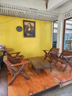 a room with chairs and a clock on a yellow wall at 205-Olan Place Homely room Free Wi-Fi and Near BTS line in Ban Yang