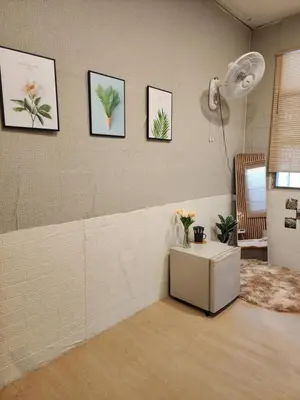 a room with a table and some pictures on the wall at 205-Olan Place Homely room Free Wi-Fi and Near BTS line in Ban Yang