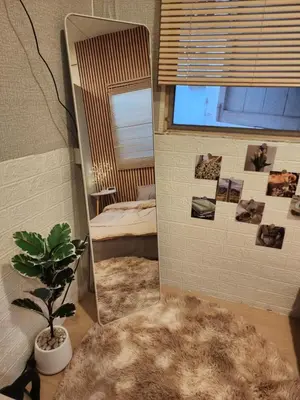 a mirror in a room with a bed and a plant at 205-Olan Place Homely room Free Wi-Fi and Near BTS line in Ban Yang
