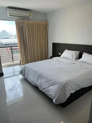 a bedroom with a bed and a large window at Tongyang House Serviced Apartment in Bangkok