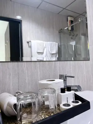 a bathroom with a sink and a mirror at Tongyang House Serviced Apartment in Bangkok