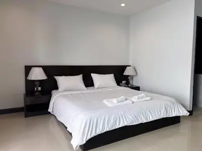 a bedroom with a large bed with two towels on it at Tongyang House Serviced Apartment in Bangkok