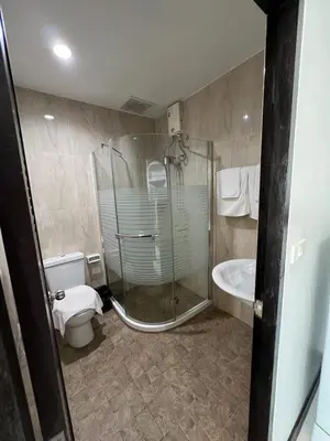 a bathroom with a shower and a toilet and a tub at Tongyang House Serviced Apartment in Bangkok