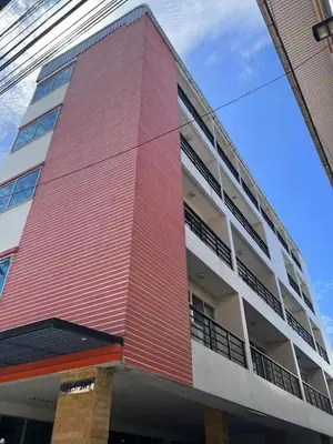 a red and white building with a sky at Tongyang House Serviced Apartment in Bangkok
