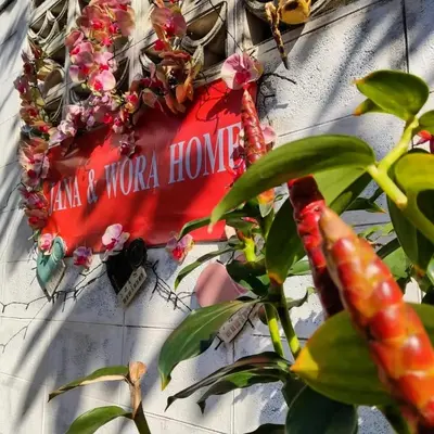 a sign on the side of a building with a plant at Worakarn Apartment 3 in Bangkok