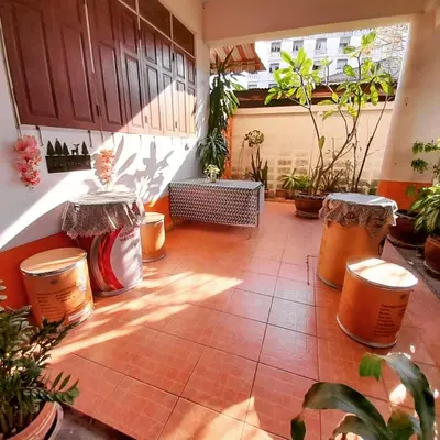 a patio with two tables and potted plants at Worakarn Apartment 3 in Bangkok