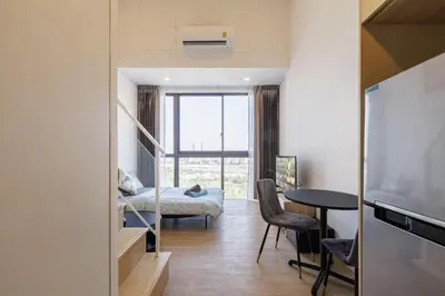a living room with a bed and a table at Loft Pool Superior Suite Near jodd Night Market 500mbps Wi-Fi Twin in Bangkok