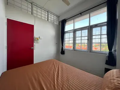 a bedroom with a red door and two windows at Merry V Guesthouse in Bangkok