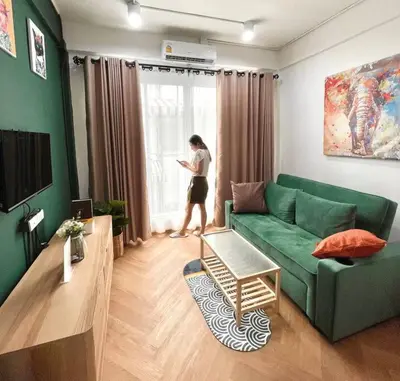a woman standing in a living room looking out the window at Entire floor,Decorated cozy home, near Grand Palace in Bangkok