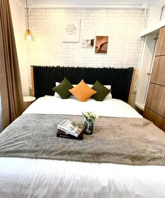 a bedroom with a white bed with green and orange pillows at Entire floor,Decorated cozy home, near Grand Palace in Bangkok