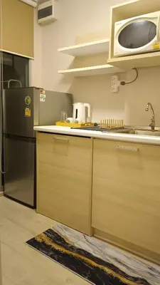 a kitchen with a refrigerator and a sink and a microwave at Elio Del Ray condo feel resort in Bangkok