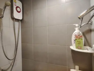 a bathroom with a shower with a bottle of soap at Elio Del Ray condo feel resort in Bangkok